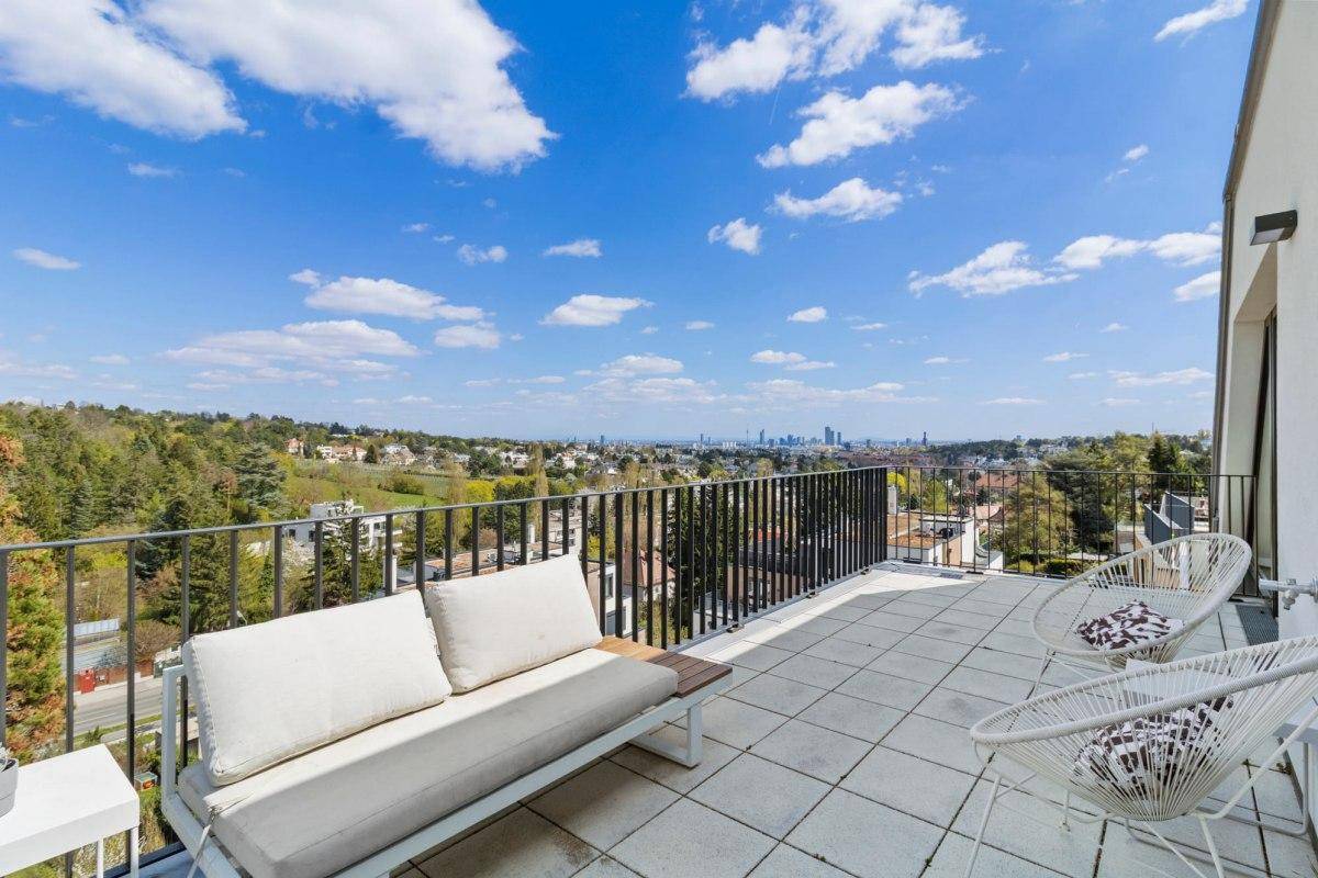 Weitläufige Terrasse mit bequemen Sitzgelegenheiten und beeindruckendem Stadt- und Landschaftsblick.
