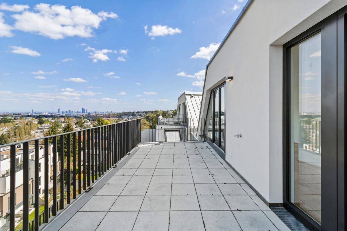 Weitläufige Terrasse mit Fliesenboden und Panoramablick auf die Stadt und die Umgebung.