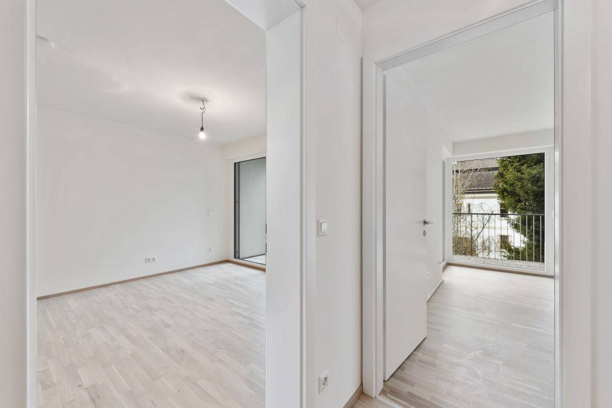 Heller Flur mit Parkettboden, der verschiedene Räume der Wohnung miteinander verbindet.