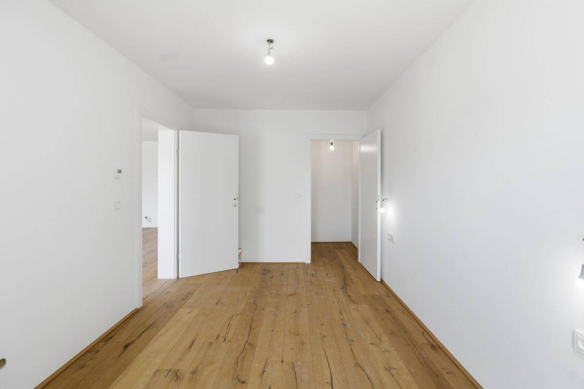 Offener Bereich mit Holzfußboden und mehreren Türen, verbindet verschiedene Wohnbereiche.