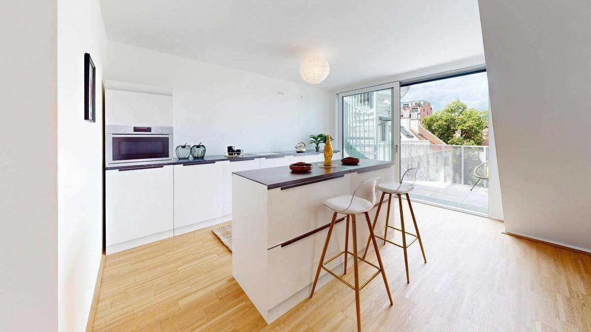 Moderne Küche mit weißer Einbauküche, Kücheninsel und direktem Zugang zum Balkon.