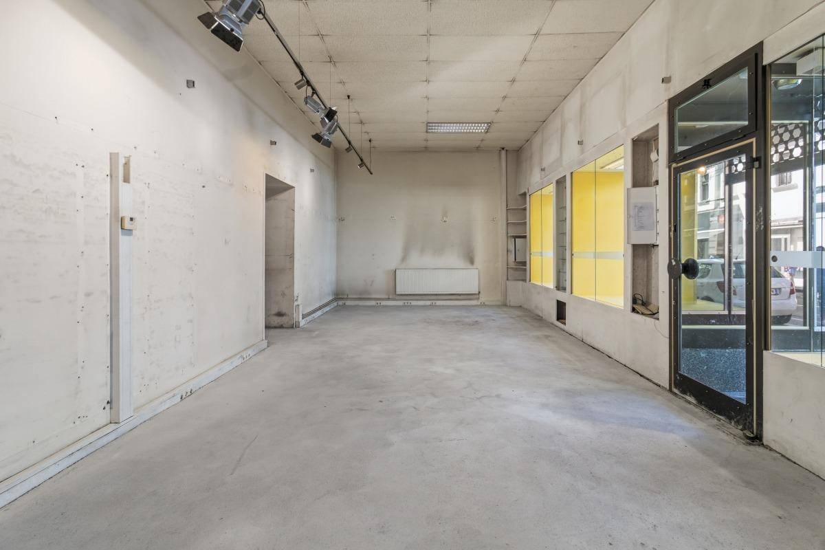 Geräumiger Ladenraum mit Betonboden, Schaufenstern und Deckenbeleuchtung, der vielseitig nutzbar ist.