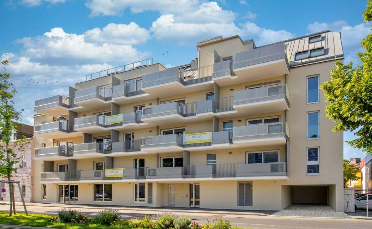 Ansicht eines modernen Wohngebäudes mit gestuften Balkonen und heller Fassade.