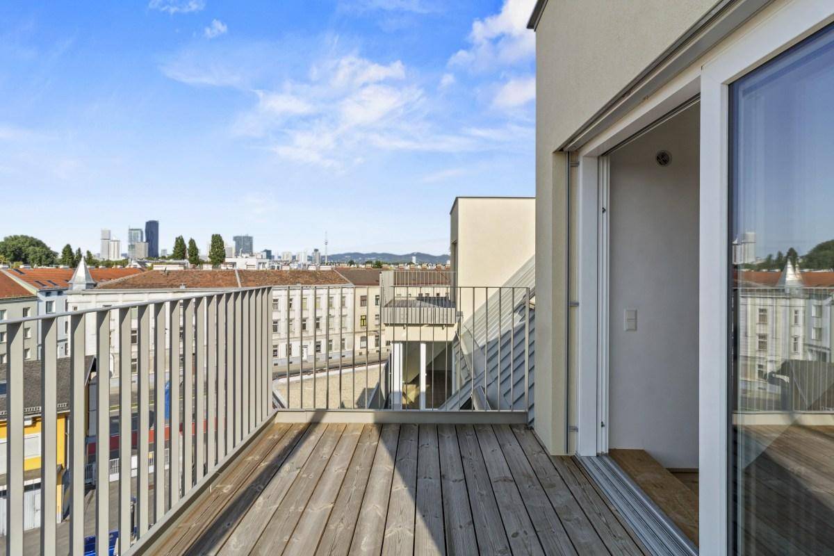 Helle Dachterrasse mit Holzboden, Metallgeländer und Panoramablick auf die Stadt.