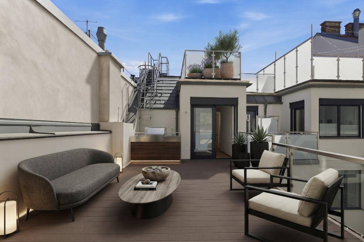 Große Dachterrasse mit Lounge-Möbeln, Außenküche und Blick über die Dächer der Stadt.