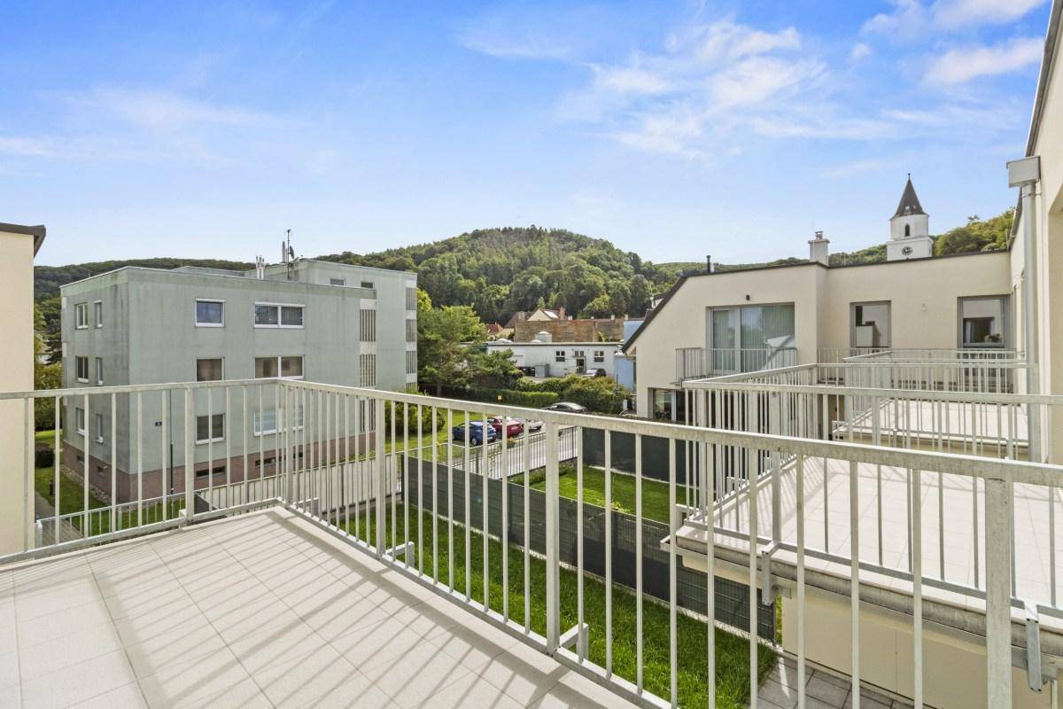 Ein Balkon mit Fliesenboden und Metallgeländer bietet einen weiten Blick auf die Umgebung.
