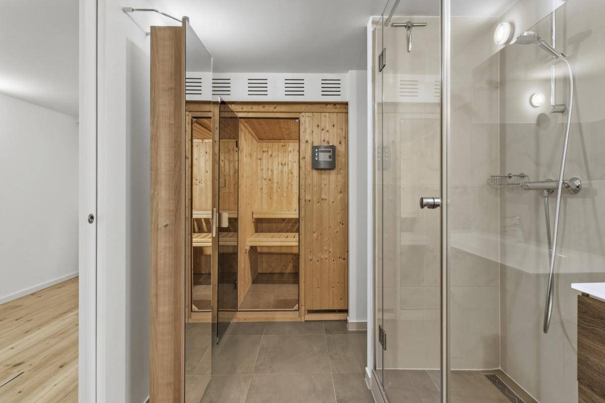 Badezimmer mit integrierter Sauna und moderner Glasdusche für entspannende Momente.
