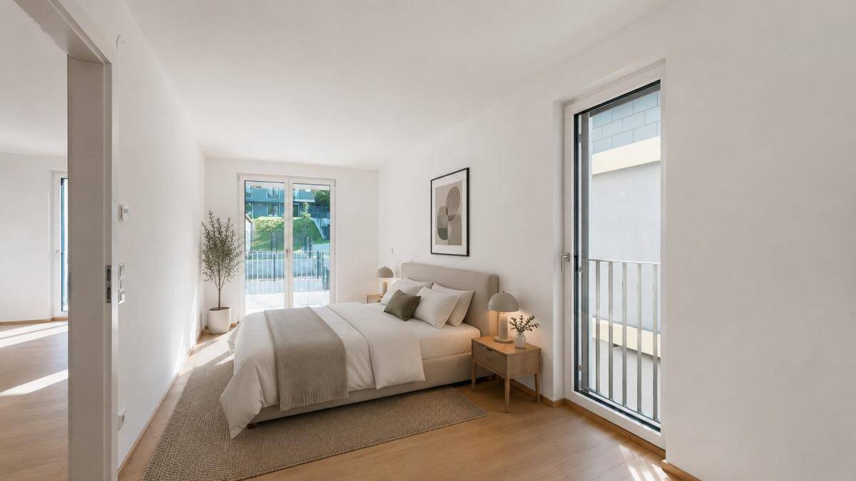 Helles Schlafzimmer mit modernem Bett, Holzboden und Zugang zu einem französischen Balkon.