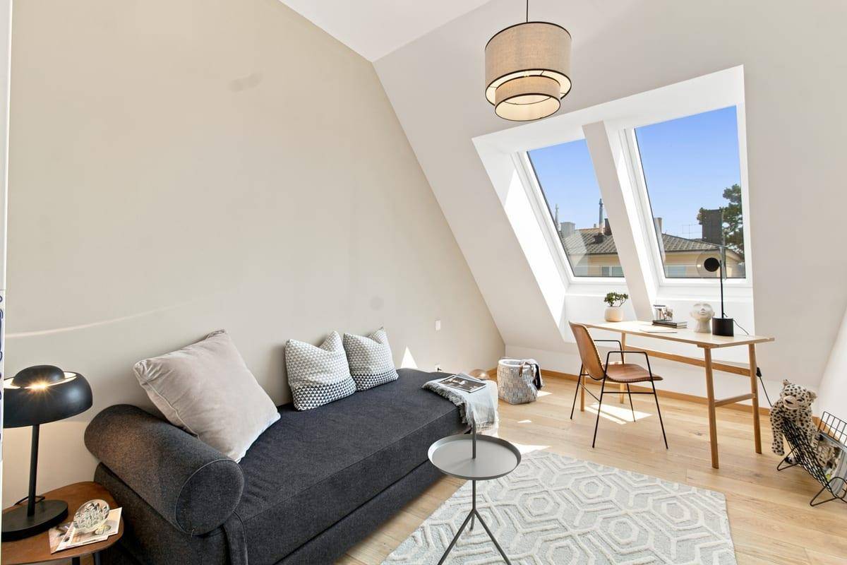 Helles Arbeitszimmer mit Tagesbett, Schreibtisch und zwei großen Dachfenstern.
