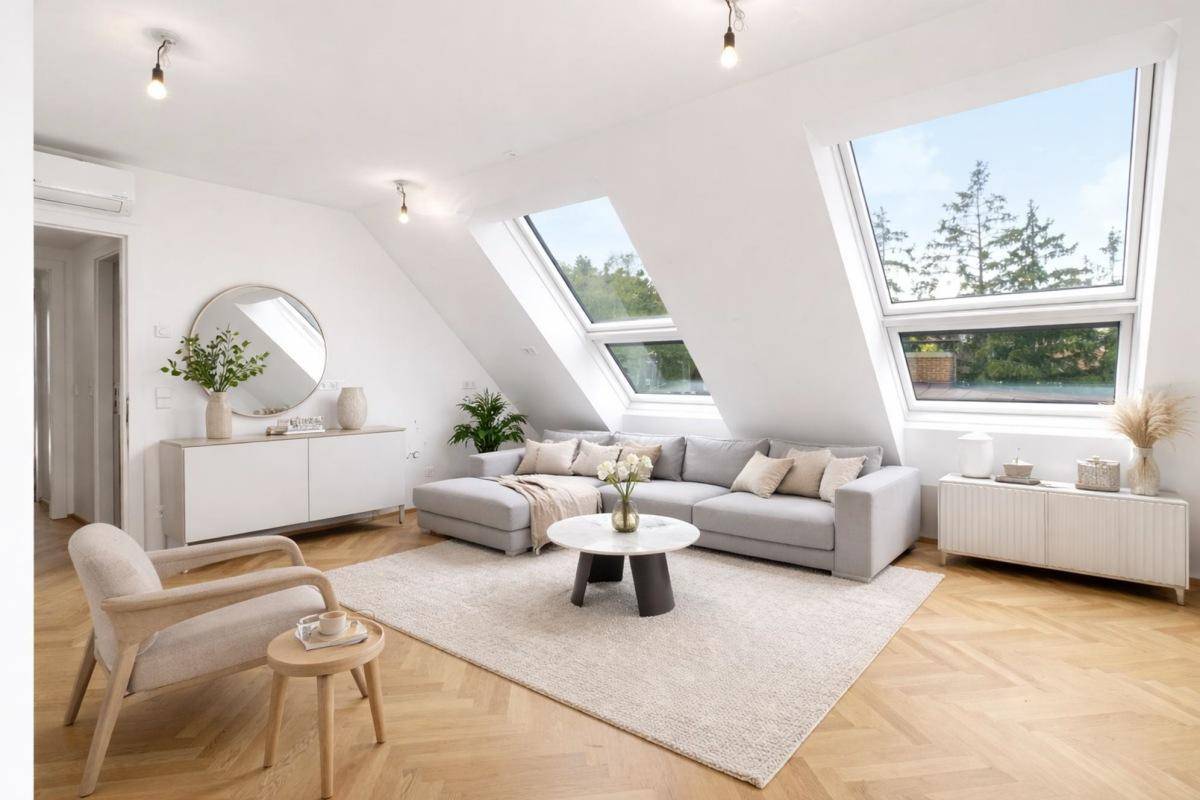 Gemütliches Wohnzimmer mit modernem Sofa, Teppich und viel Tageslicht durch Dachfenster.
