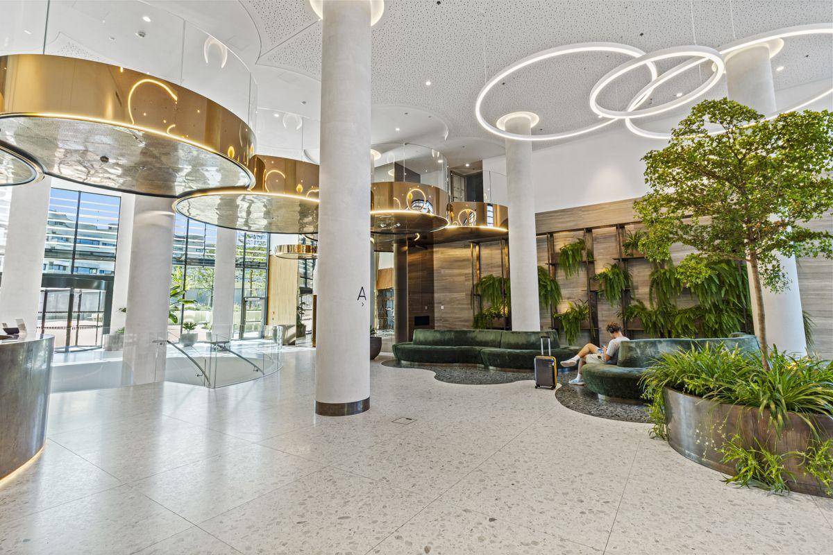 Luxuriöse Lobby mit hohen Decken, moderner Beleuchtung und stilvollen Sitzgelegenheiten.