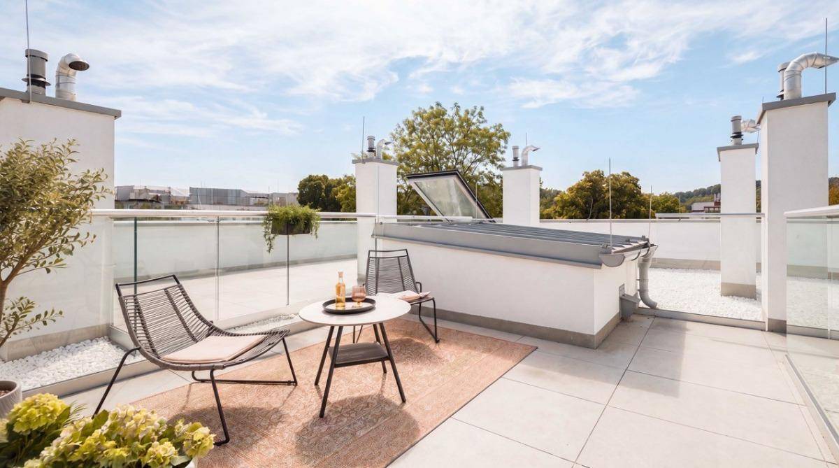 Helle Dachterrasse mit Sitzgelegenheiten, großem Dachfenster und Panoramablick.