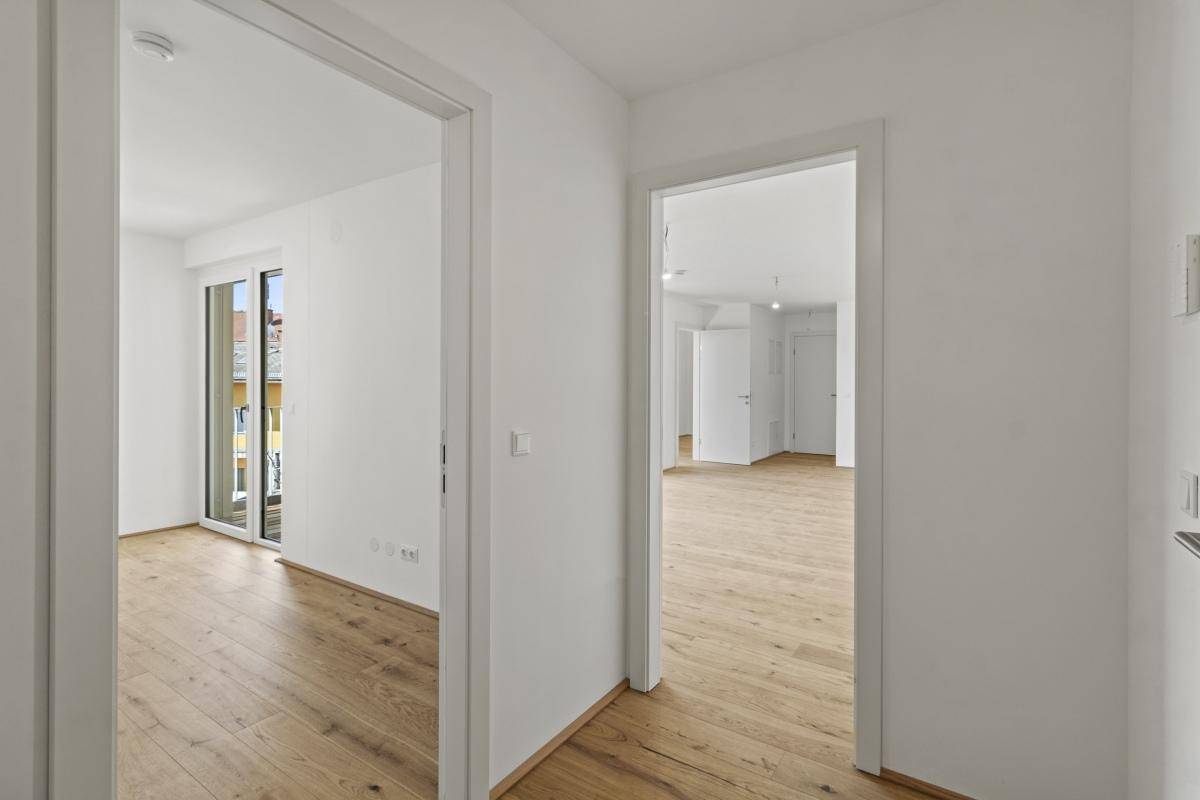 Heller Flur mit Parkettboden, der zu verschiedenen Zimmern der Wohnung führt.