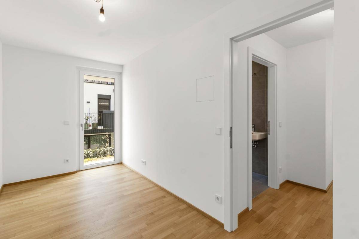 Schlafzimmer mit Zugang zu einem Badezimmer und Blick auf den Außenbereich.