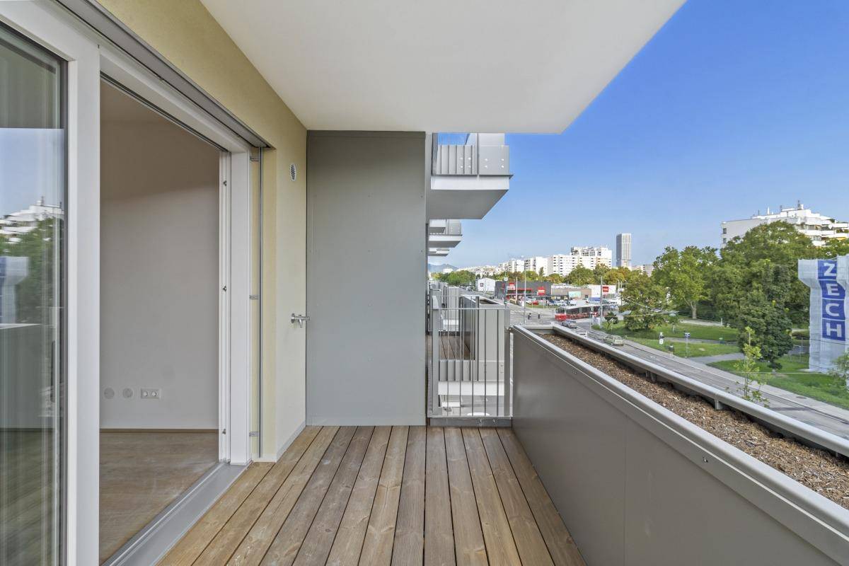 Balkon mit Holzboden und weitem Blick über die Stadt und die umliegende Bebauung.