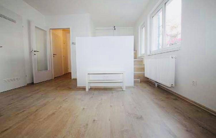 Wohnraum mit großen Fenstern, Heizkörper und einer integrierten Hochbett-Konstruktion.