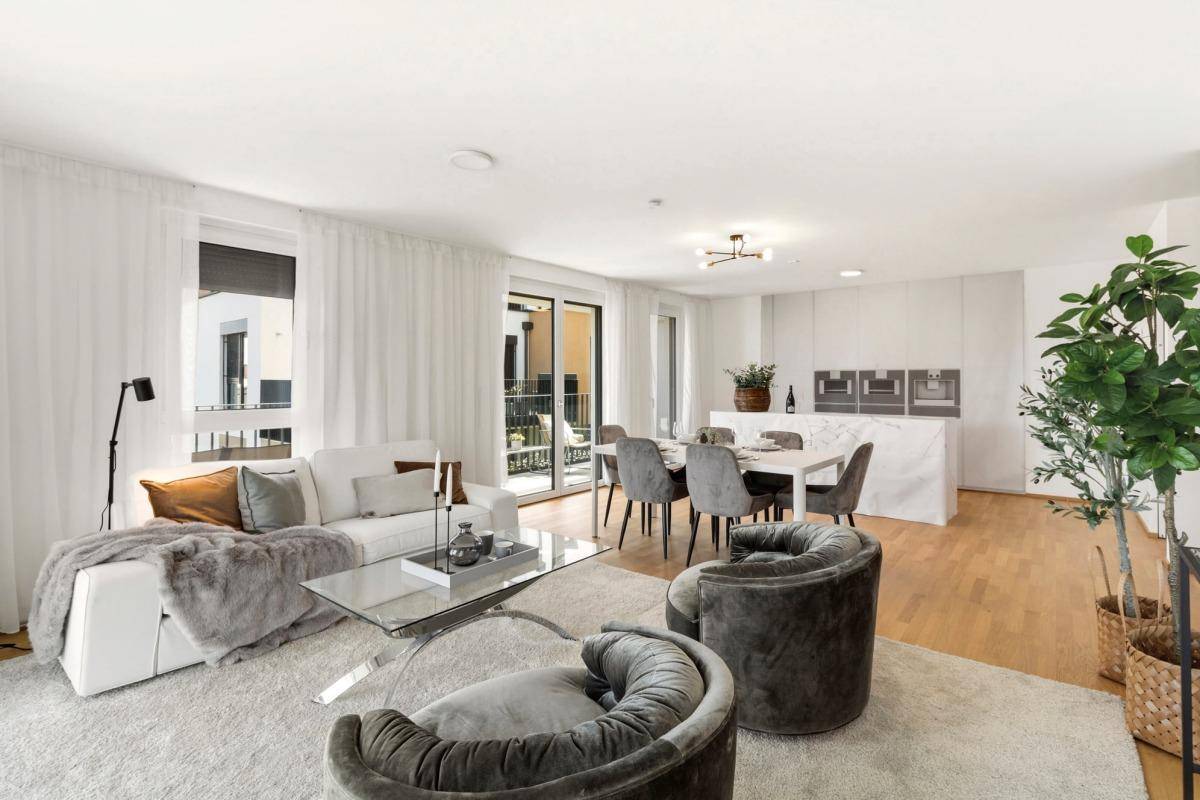 Heller, offener Wohn- und Essbereich mit modernem Design, Parkettboden und Zugang zum Balkon.