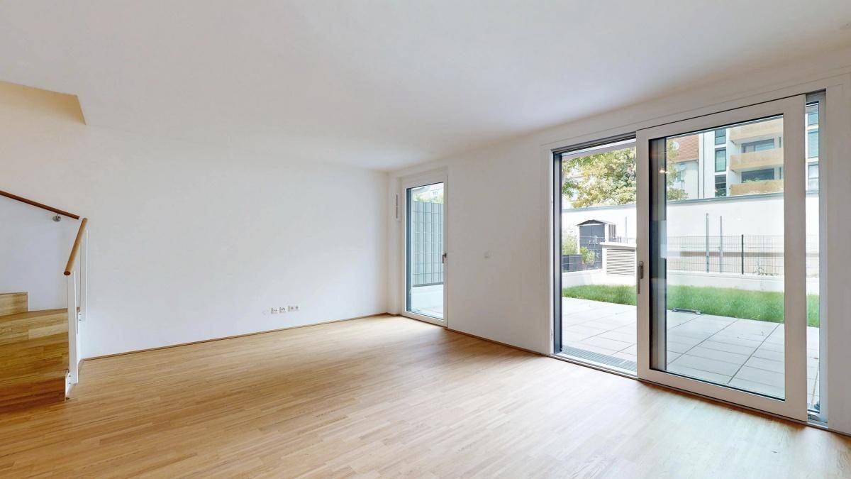Lichtdurchfluteter Wohnbereich mit großen Schiebetüren zum Garten und Terrasse.