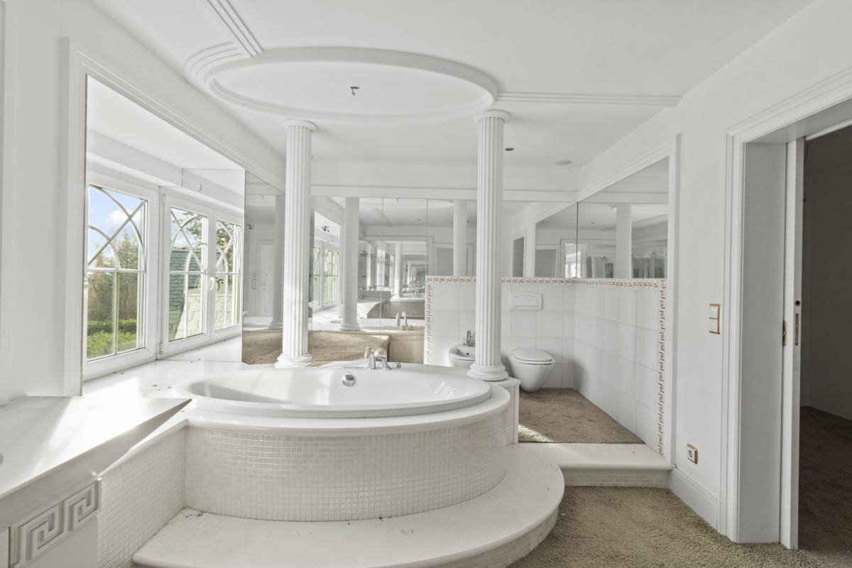 Elegantes Badezimmer mit großer Badewanne, Bidet und Säulen, die einen luxuriösen Stil unterstreichen.