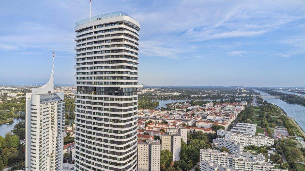 Architektonisch markantes Hochhaus mit geschwungenen Balkonen und weitem Blick über die Stadt.