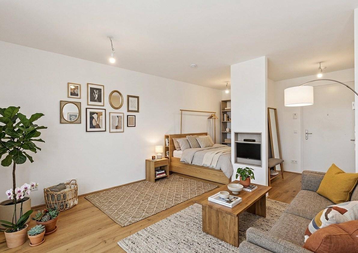 Helles Studio-Apartment mit offenem Wohn- und Schlafbereich sowie Holzboden und moderner Dekoration.