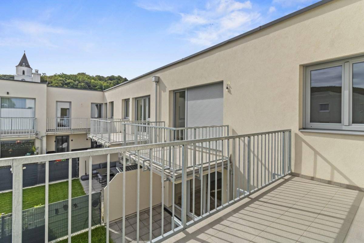 Balkon mit Blick auf den Innenhof und weitere Balkone des modernen Wohnkomplexes.