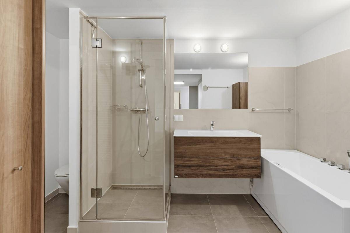 Modernes Badezimmer mit begehbarer Dusche, Badewanne und elegantem Waschtisch.