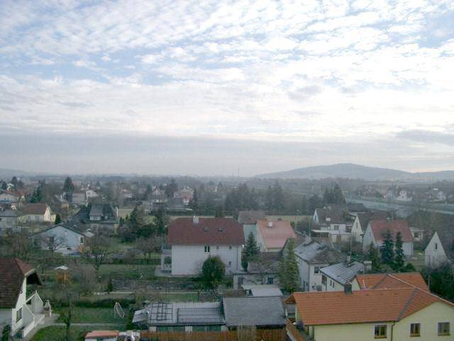 Panoramablick über eine Wohngegend mit Häusern und bewölktem Himmel.