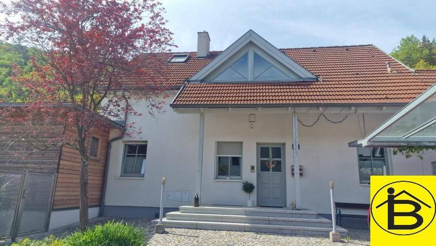 Ansprechende Hausfassade mit Satteldach, großen Fenstern und gepflegtem Eingangsbereich.