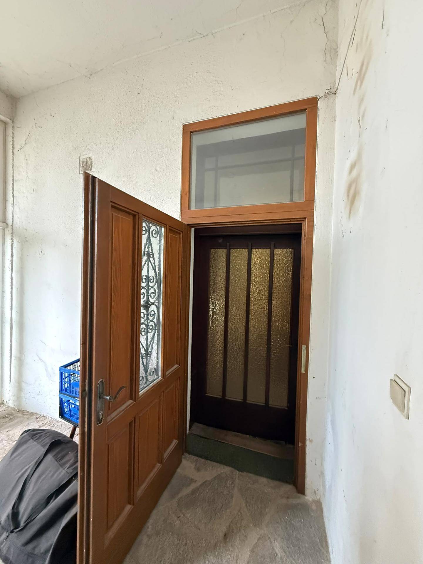Eingangsbereich mit zwei Holztüren, eine davon mit strukturiertem Glas.