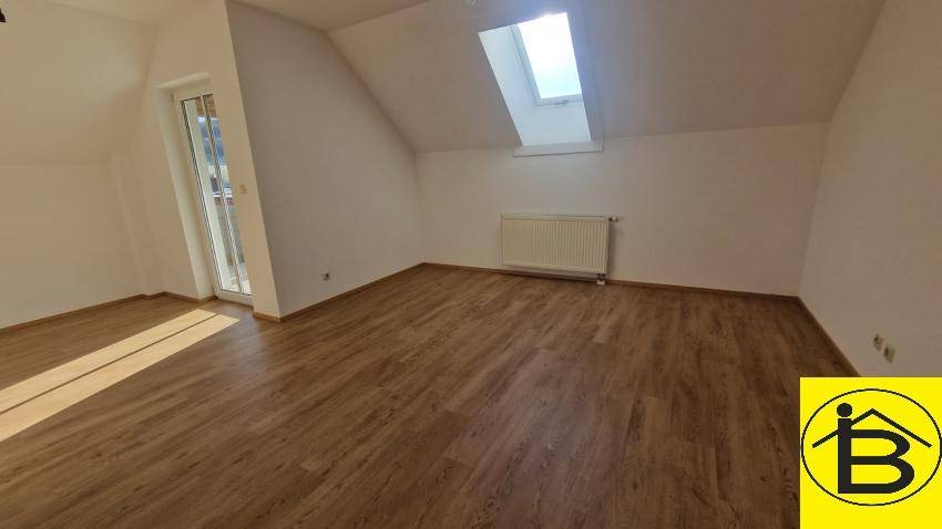 Helles Zimmer mit Holzboden, Dachfenster und Balkonzugang, ideal als Schlafzimmer.