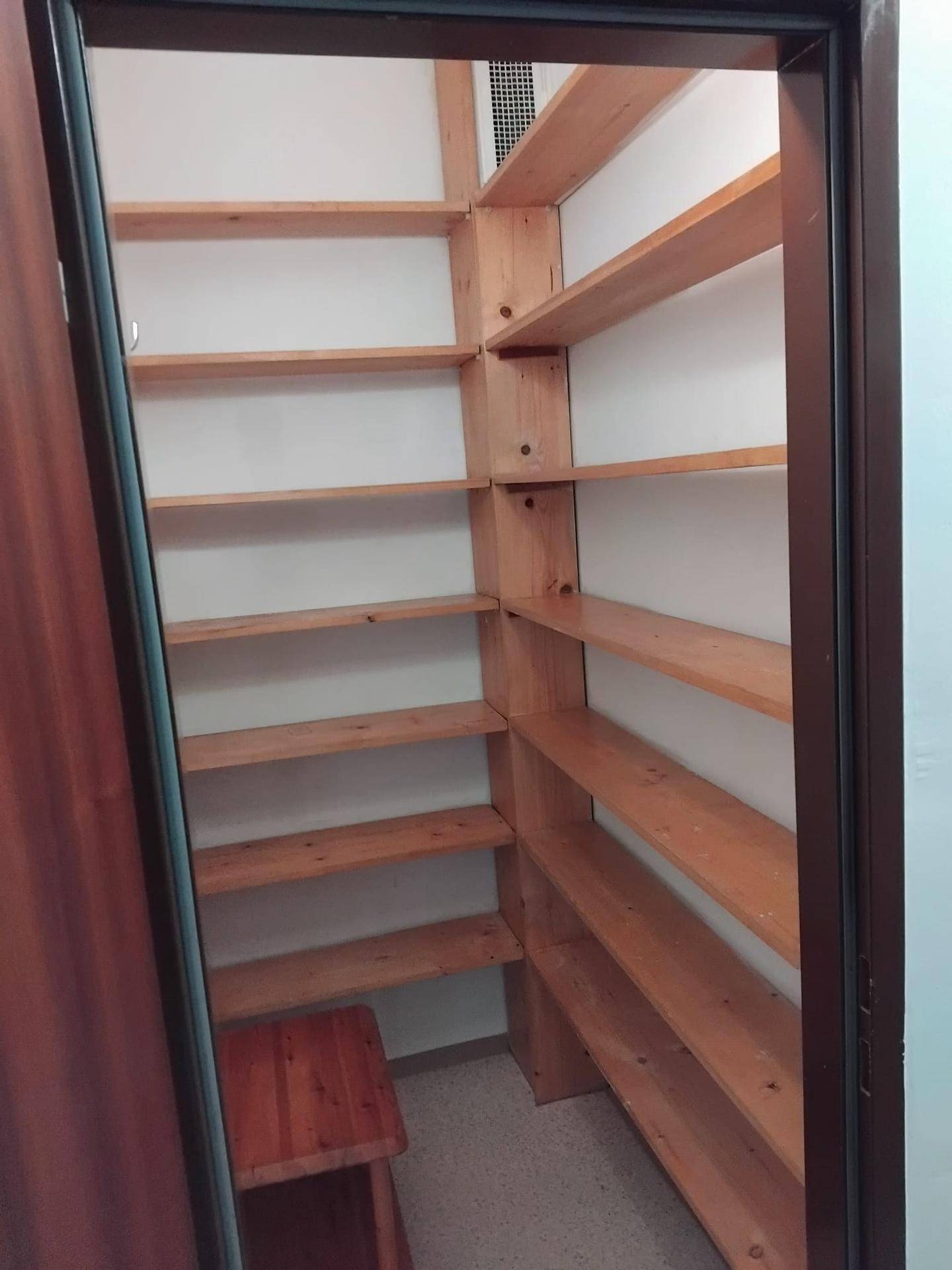 Praktischer Abstellraum mit vielen Holzregalen für zusätzlichen Stauraum.