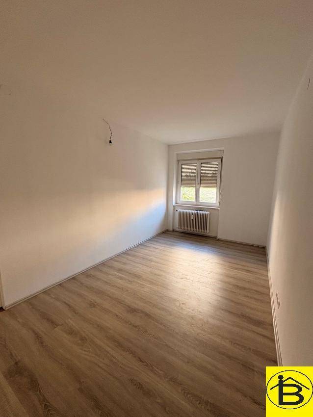 Helles Zimmer mit neuem Laminatboden und weiß gestrichenen Wänden, bietet eine angenehme Atmosphäre.