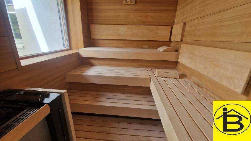 Moderne Holzsauna mit mehreren Bänken und Heizofen für Entspannung.