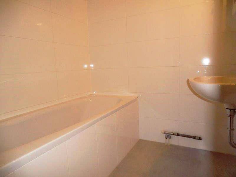 Helles Badezimmer mit einer eingebauten Badewanne und einem Waschbecken.