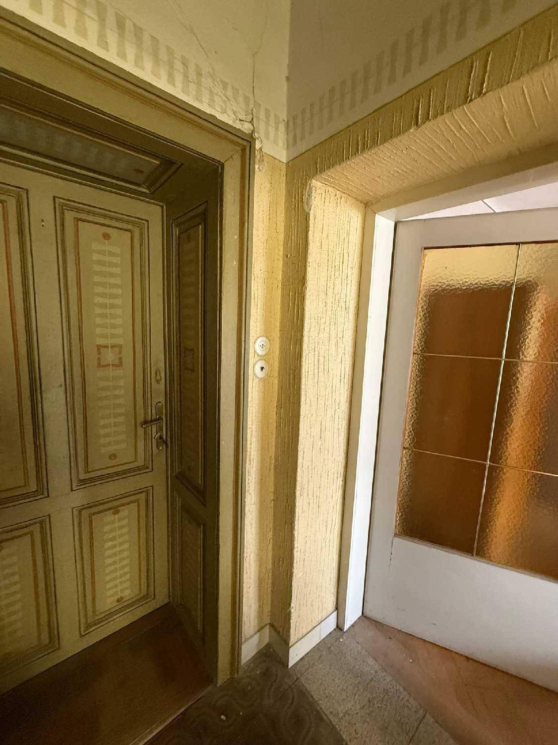 Ecke eines Flurs mit zwei Türen, eine davon reich verziert, die andere mit Glas.