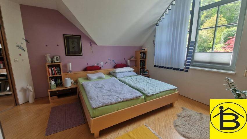 Gemütliches Schlafzimmer im Dachgeschoss mit Holzboden, Doppelbett und Blick ins Grüne.