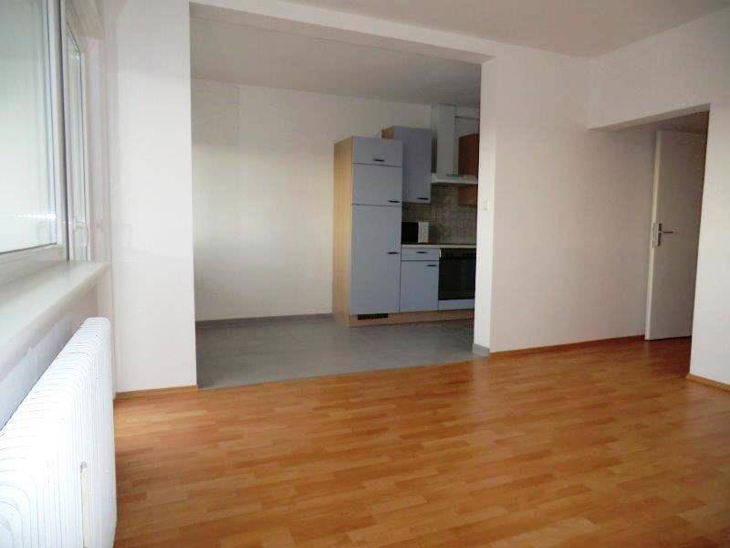 Offener Wohnbereich mit Blick auf die angrenzende Küche und hellem Laminatboden.