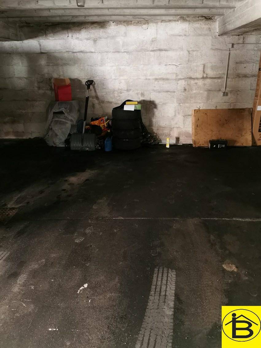 Funktionale Garage mit robusten Betonwänden und praktischem Stauraum für diverse Gegenstände.