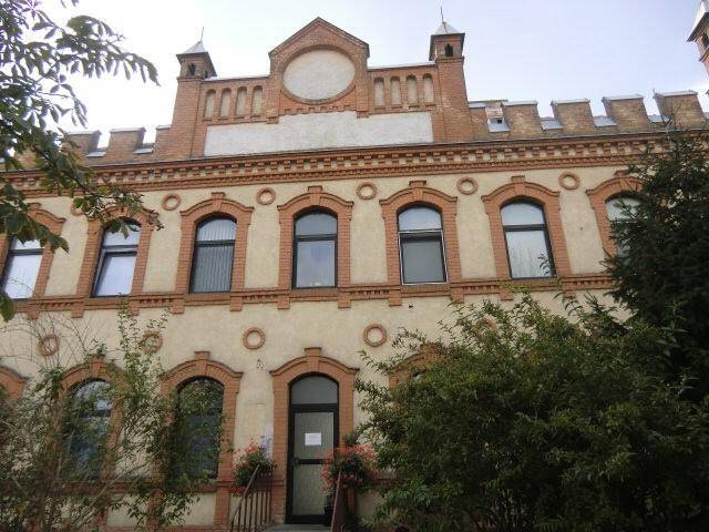 Detailansicht der historischen Fassade mit dekorativen Elementen und vielen Fenstern.