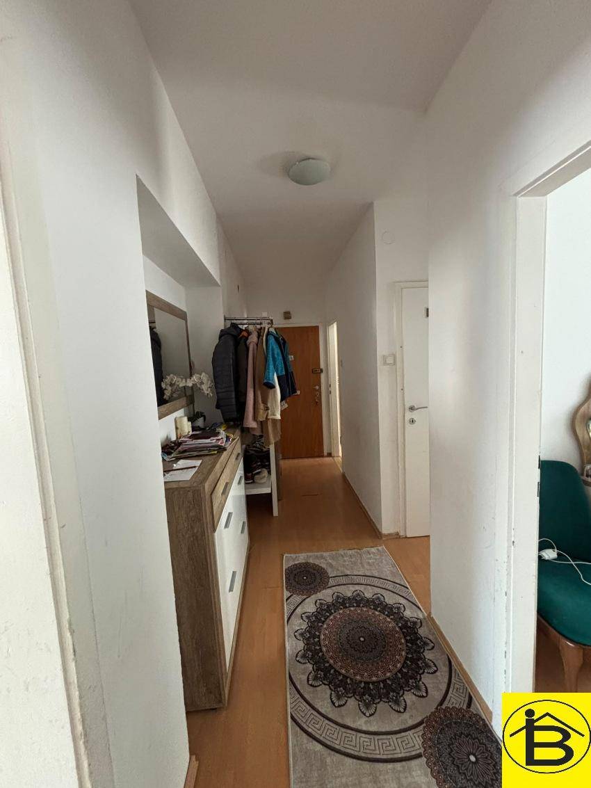 Heller Flur mit Garderobe, Spiegel und Stauraum, der zu den weiteren Räumen führt.