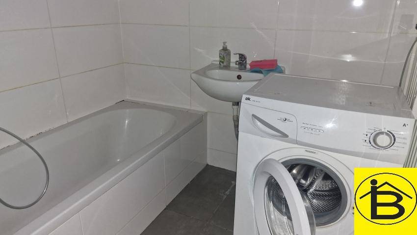 Badezimmer mit Badewanne, Waschbecken und Waschmaschine.