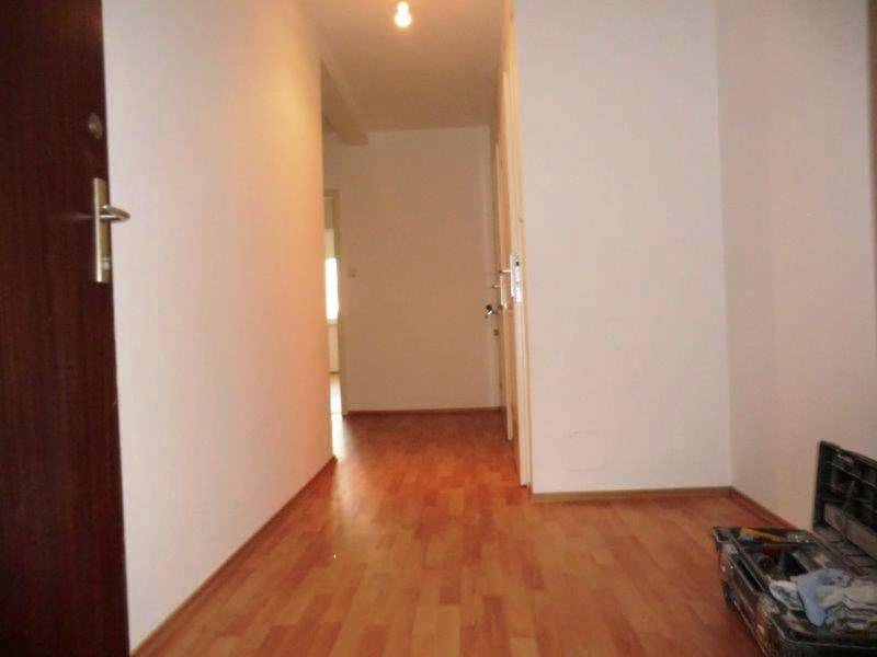 Geräumiger Flur mit hellem Laminatboden und Zugang zu verschiedenen Zimmern.