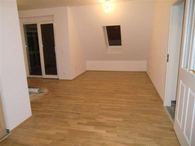 Heller Raum im Dachgeschoss mit Holzboden und Dachfenster für viel natürliches Licht.