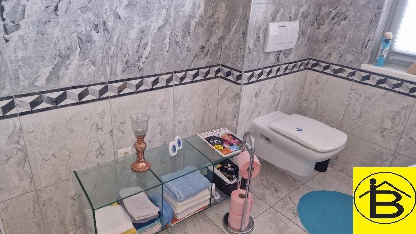 Separate Toilette mit wandhängendem WC und modernen Fliesen.