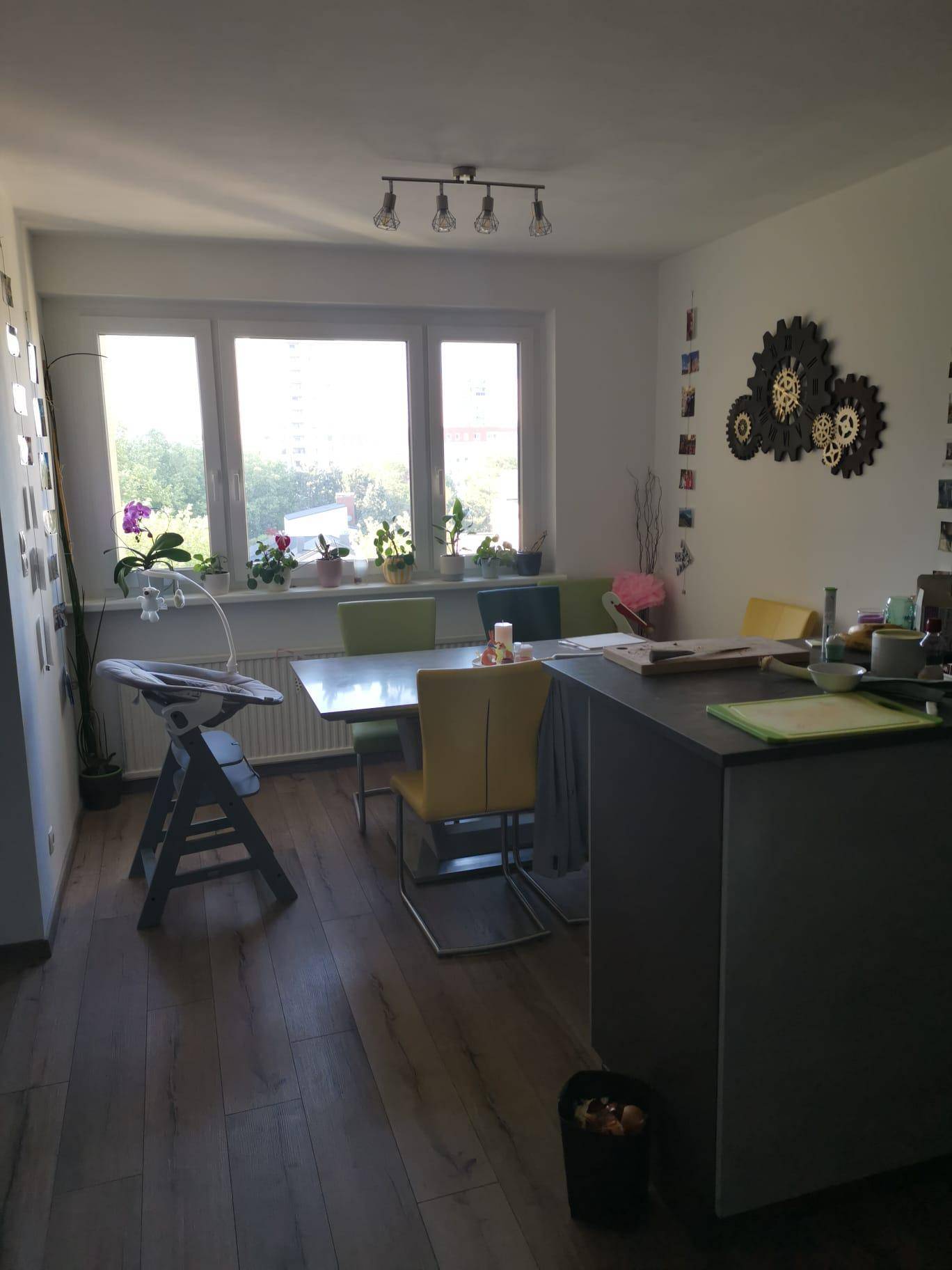 Heller Essbereich mit großem Fenster, Holzboden und moderner Dekoration.