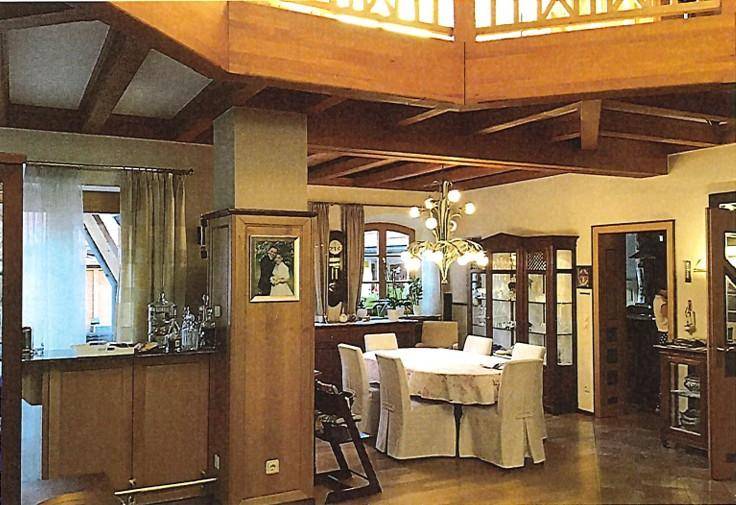 Eleganter Essbereich mit großem Tisch, Vitrinen und einer integrierten Bar.