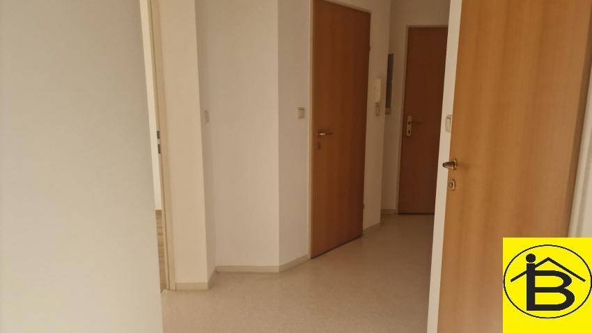 Heller Flur mit mehreren Holztüren und hellem Bodenbelag, der zu den Zimmern führt.