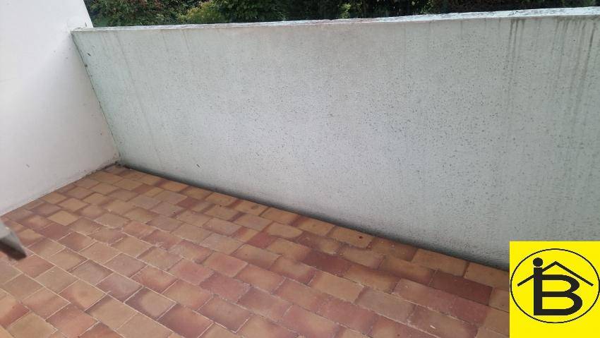 Kleiner Balkon mit Fliesenboden und hoher Brüstung, ideal für Entspannung.