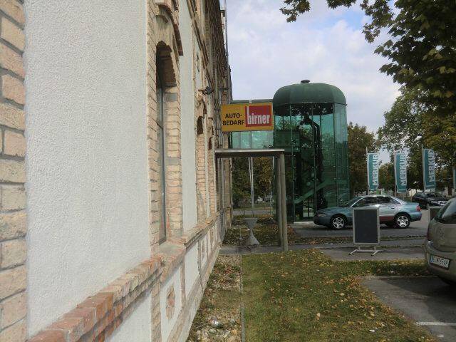 Fassade eines Gebäudes mit traditionellen Elementen und einem modernen Glasanbau.